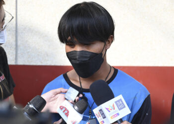 Woman in Thailand’s high-rise cuts rope holding painters